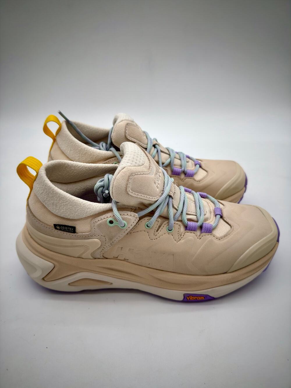Hoka Beige Athletic Sneakers with Yellow Pull Tabs and Purple Accents
